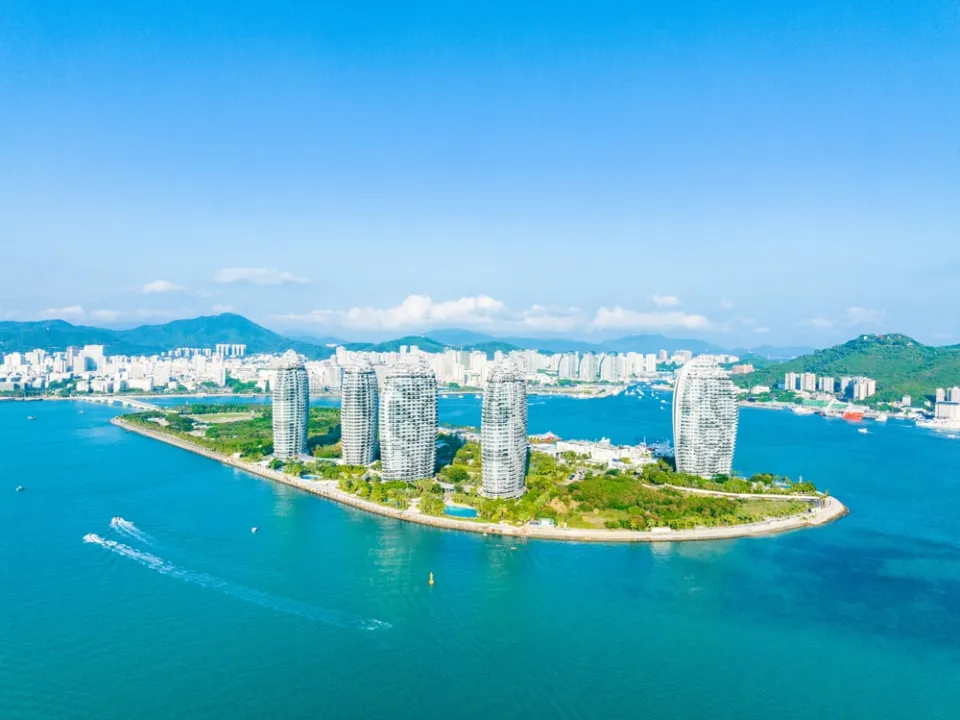 Панорама побережья Санья на Хайнане — тропические пляжи, отели и горы на горизонте